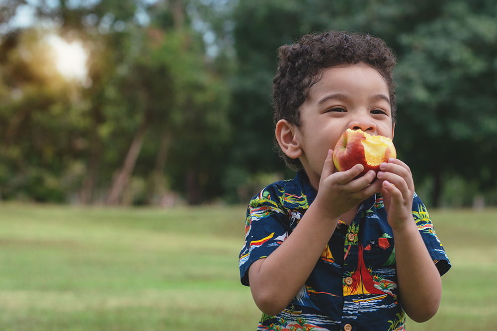 enfant croquant une pomme